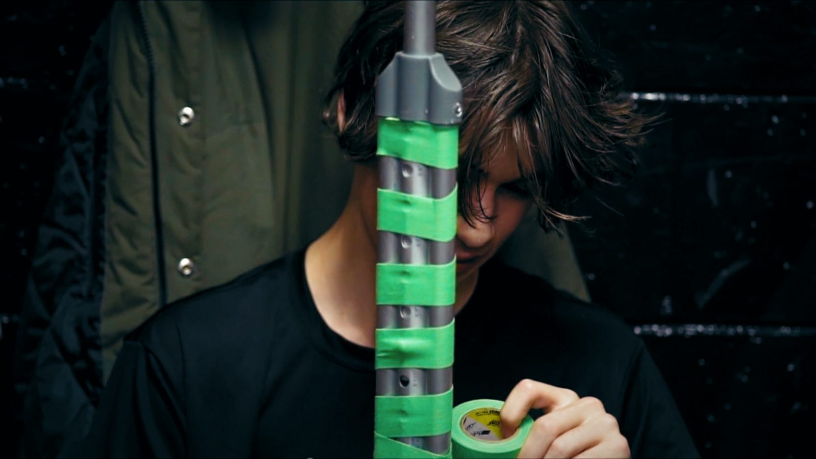 A young player taping a stick handle in green